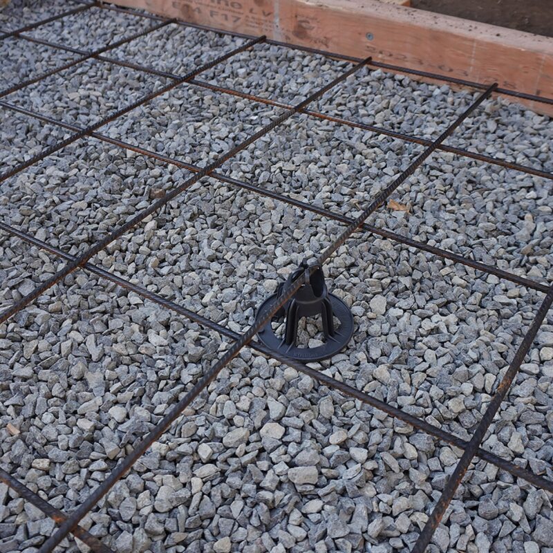 Pack of 50–65mm plastic bar chairs used to support reo bars or mesh in garden bed or concrete reinforcement setups.